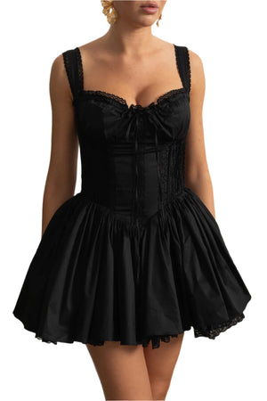 Black dress with lace details on a white wall background