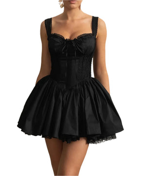 Woman wearing a black dress with a white decorative wall background
