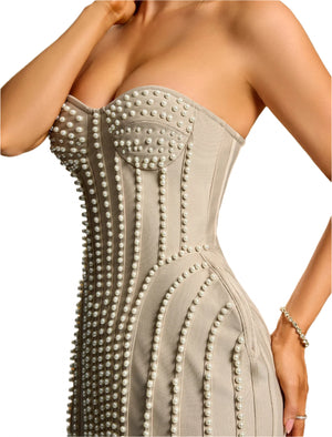 Gray strapless dress with pearl embellishments on a model against a beige background