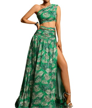 Woman wearing a green leaf-patterned two-piece outfit with a slit skirt on a gradient background