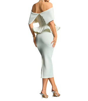 Woman wearing a white off-shoulder dress with ruffled details against a gradient background