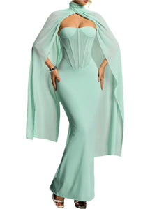 Mint green strapless dress with a flowing cape on a gradient background