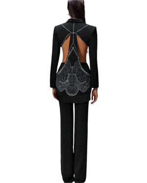 Black outfit with intricate back design on a gray background