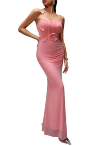 Woman wearing a pink evening gown against a gray background