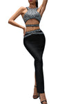 Woman wearing a sparkling top and black pants on a gray background