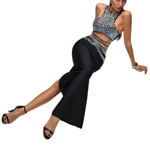 Woman in a silver sequin top and black pants sitting on a gray block.