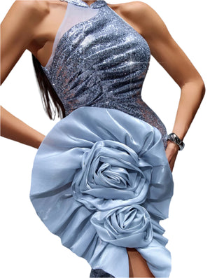 Silver sequin dress with a large blue floral embellishment on a gray background
