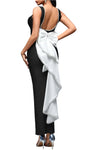 Woman wearing a black dress with a white bow on a gray background