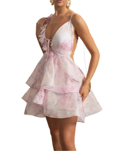 Woman wearing a pink floral dress in an elegant interior setting